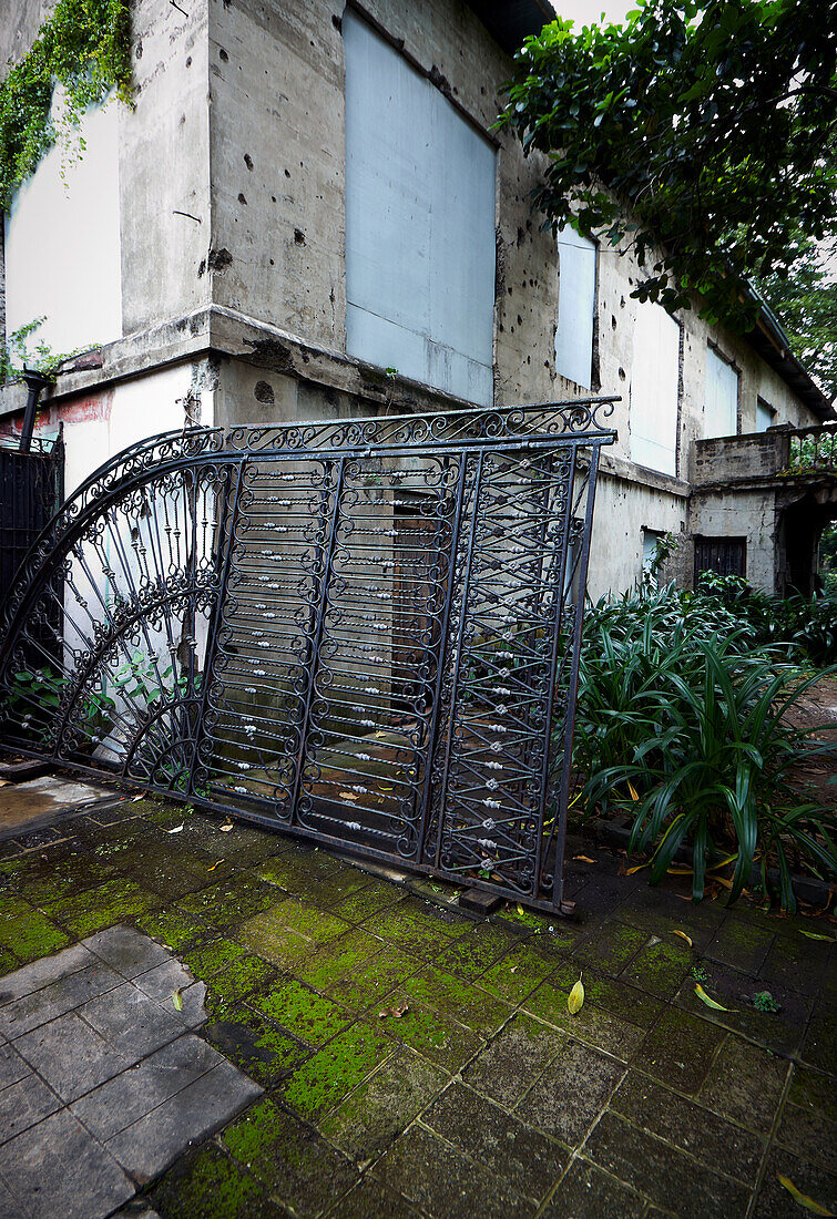 Große gewölbte Eisentore, die sich an ein altes Gebäude in Manila - Philippinen lehnen