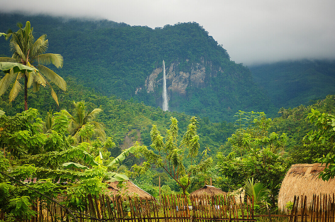 Standing in Mangyan jungle village looking up at waterfall in surrounding hills