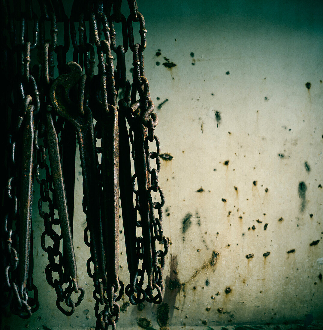 Close up of rusty chains hanging against side of ship