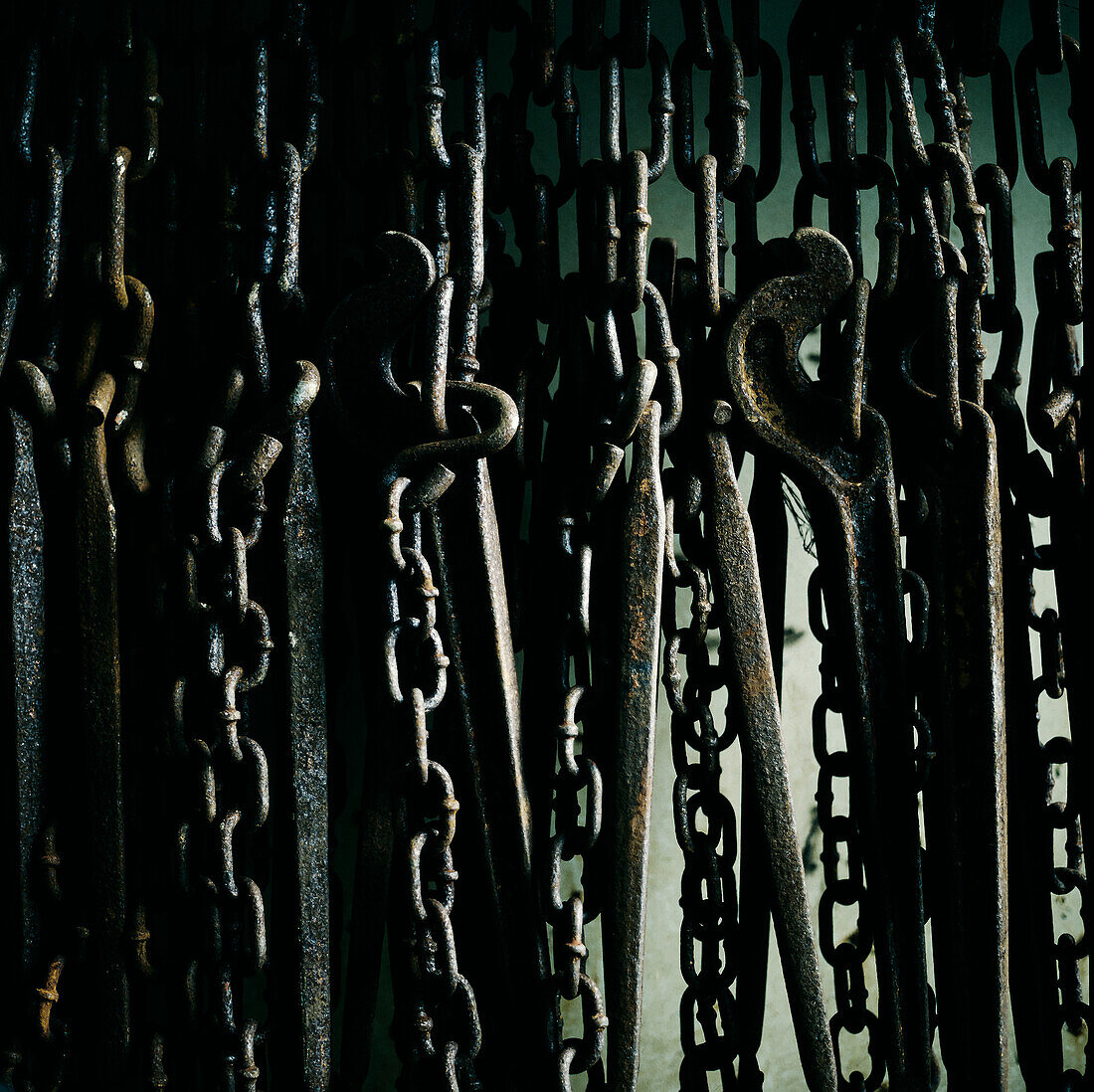 Close up of rusty chains hanging against side of ship