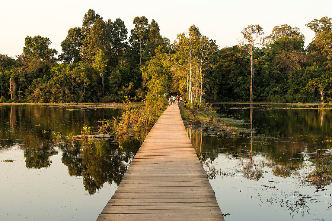 Holzsteg überquert den Pool bei Sonnenuntergang von Neak Poan im Angkor-Komplex