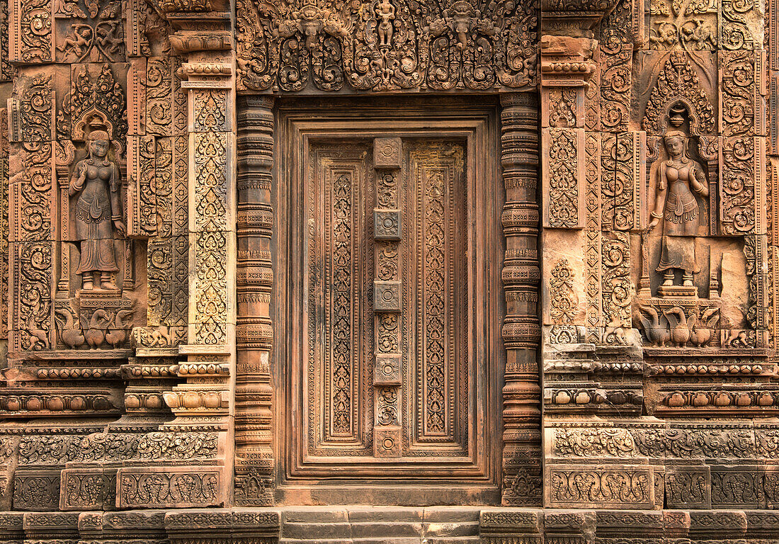 Kunstvoll geschnitzte Sandsteintür und Wände des Tempels Banteay Srei in der Region Angkor in Kambodscha. Erbaut im 10. Jahrhundert. Dem hinduistischen Gott Shiva gewidmet.