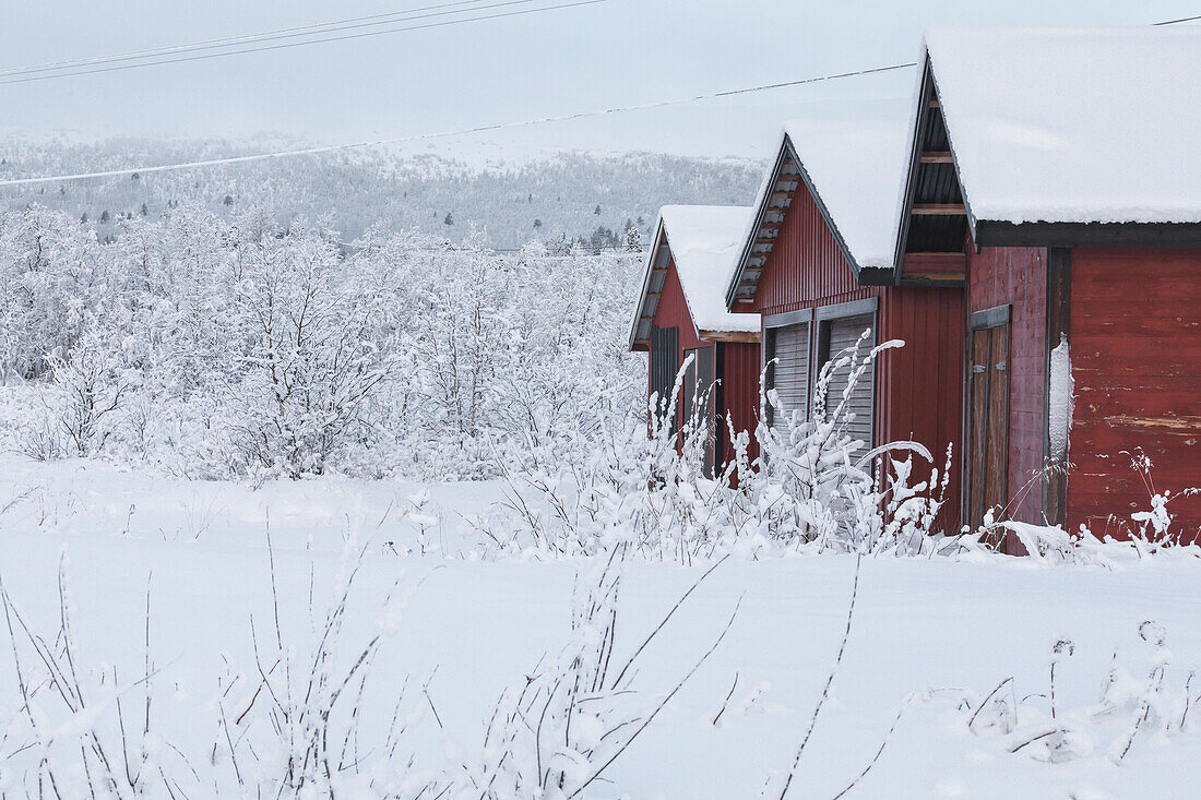 Schneebedeckte Scheunen. Winterszene in Schwedisch Lappland