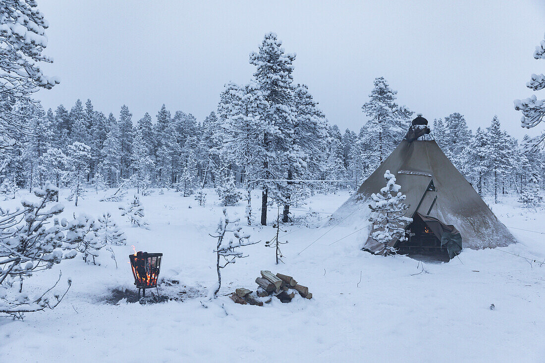 Camping-Tipi-Zelt und Feuerstelle. Winterszene in Schwedisch Lappland