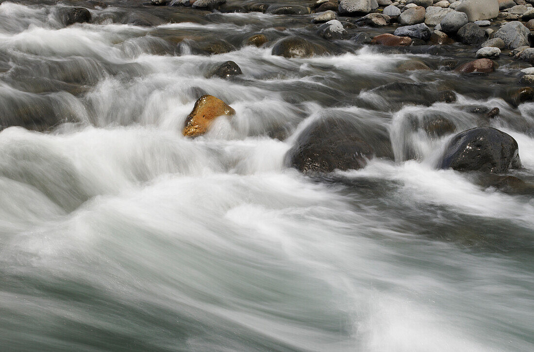 Schnell fließender Fluss über felsigem Flussbett