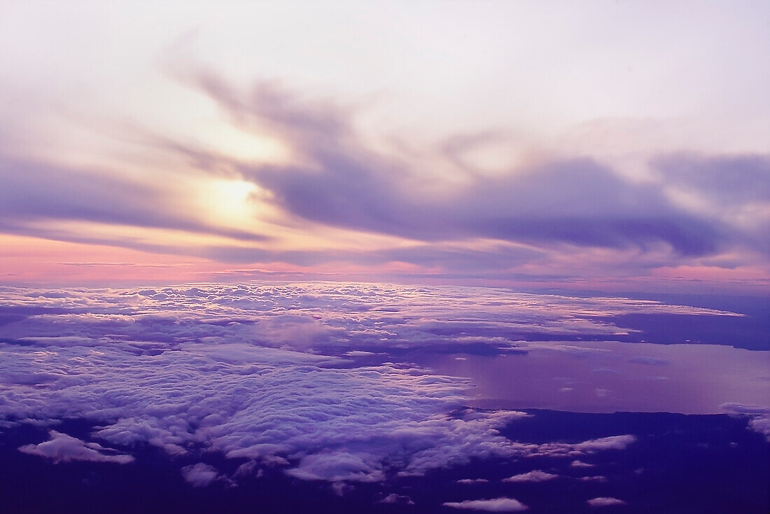 Blick nach unten auf Wolken und Sonnenuntergang