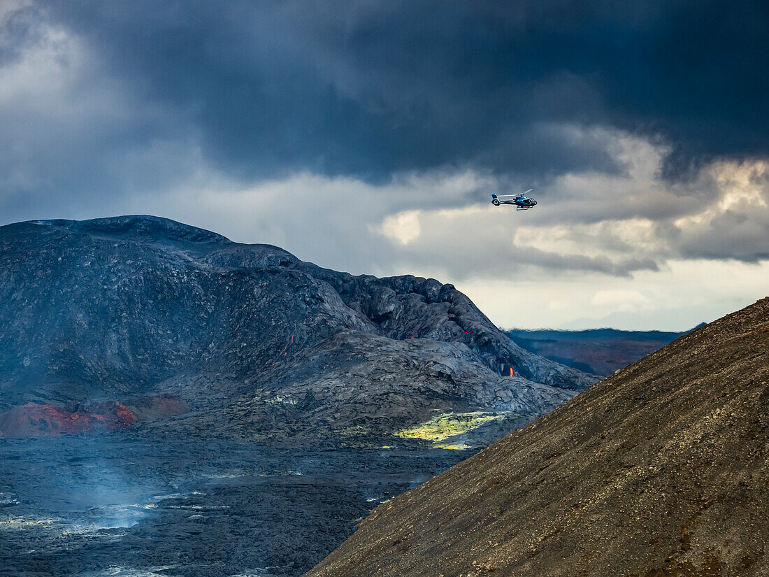Hubschrauber fliegt über Vulkankrater Fagradalsfjall zwischen Eruptionen, Island