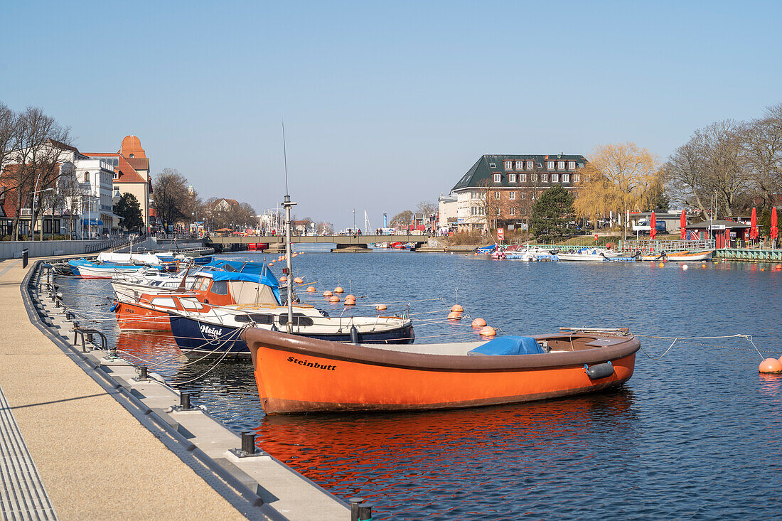 Boats on the Alter Strom in Warnemünde looking towards the station bridge in the morning.