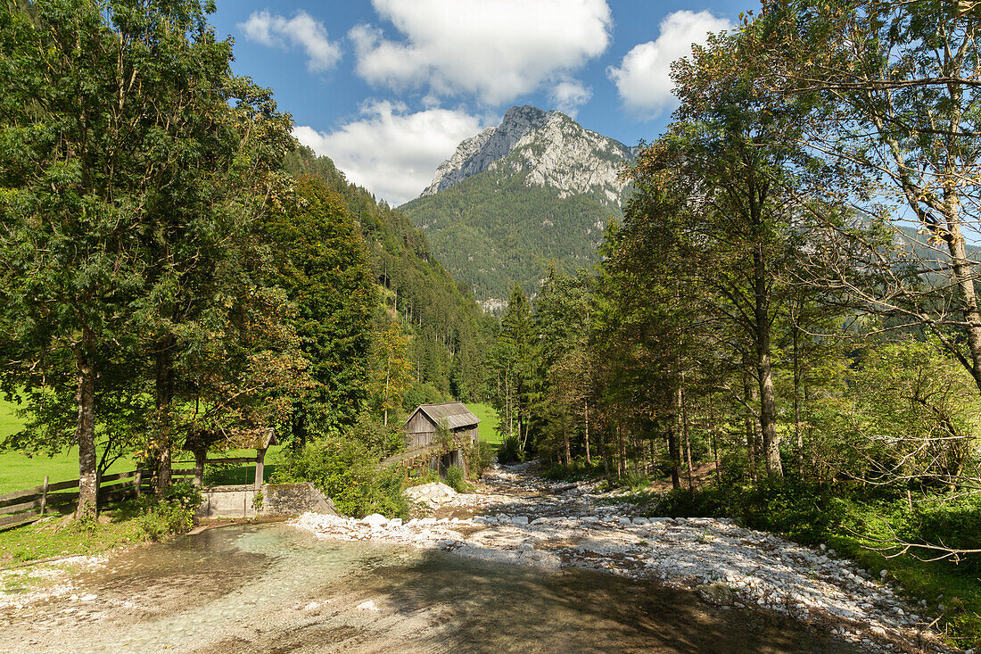 Old water mill on the Bela river.Mozirje, Solcava, Slovenia. mountains in the background