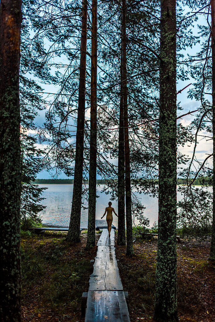 Cooling off in the lake, sauna in the middle of the forest in Patvinsuo National Park, Finland