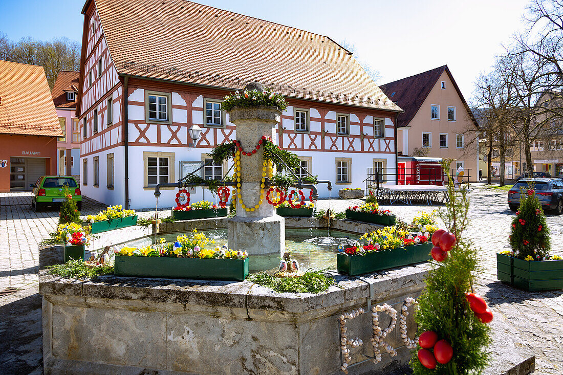 mit bunten Ostereiern geschmückter Osterbrunnen vor dem Rathaus am Marktplatz in Markt Heiligenstadt in der Fränkischen Schweiz, Bayern, Deutschland