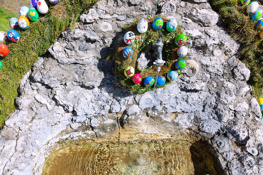 mit bunten Ostereiern geschmückter Tuffsteinbrunnen in Zoggendorf in der Fränkischen Schweiz, Bayern, Deutschland