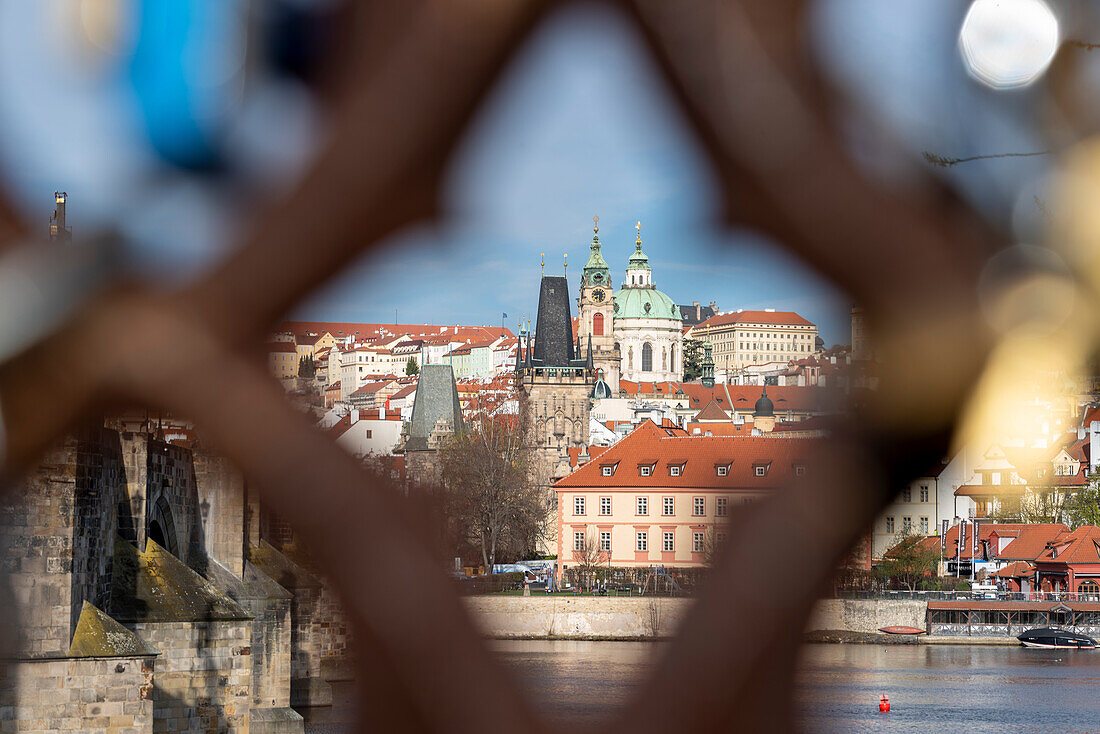 Blick durch einen Metallzaun auf Karlsbrücke und St. Nikolauskirche, Prag, Tschechien