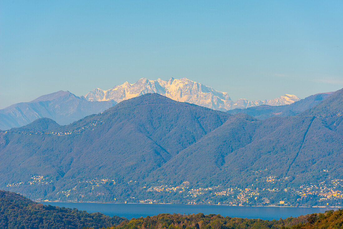 Schneebedeckter Berggipfel Monte Rosa und Lago Maggiore an einem sonnigen Tag mit klarem Himmel im Tessin, Schweiz