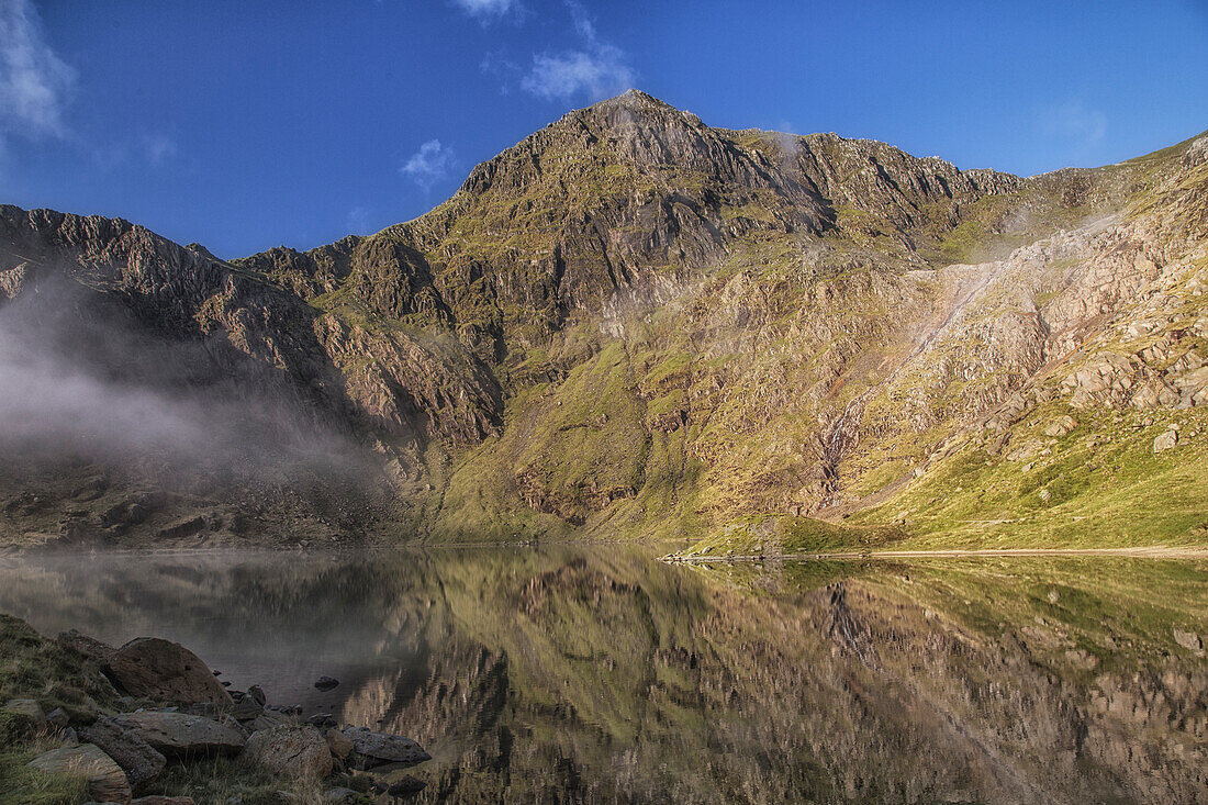 View across Lake Glaslyn to Mount Snowdon, Caernarfon, Wales, UK. mirroring in the water.