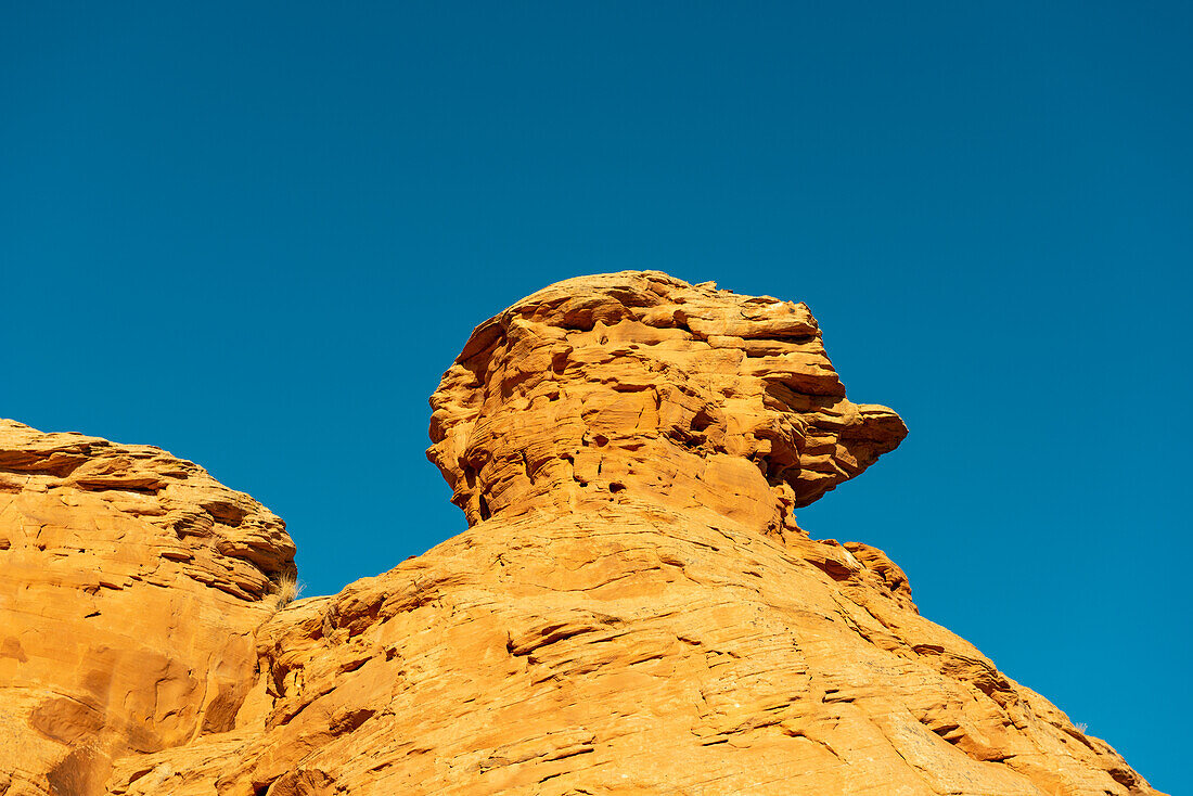 Intensely orange glowing rock formation against a blue sky, Sedona, Arizona, USA