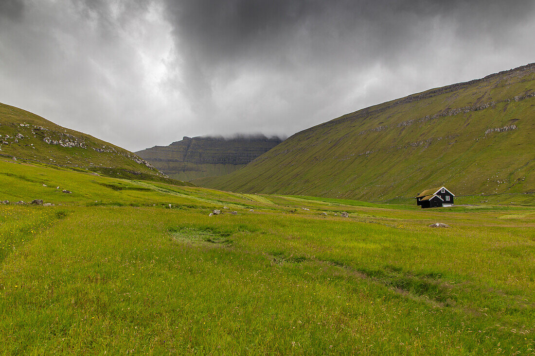 Single cottage in green hills landscape. Gjogv, Eysturoy, Faroe Islands