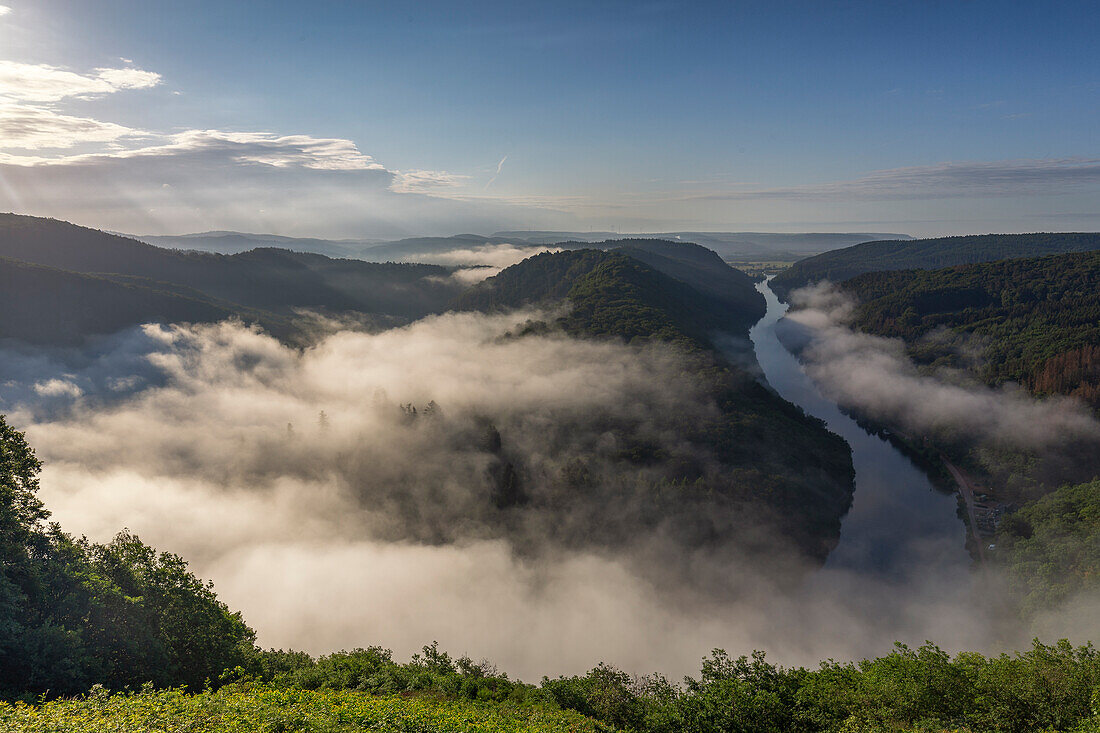 View of the Saar loop under fog with gaps, morning mood. Orscholz, Saarland, Germany.