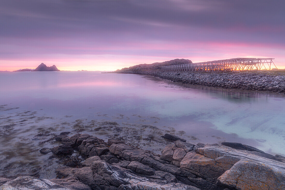 Rocky coast at Fjaervollsanden beach. Dried Fish Racks, Sunset, Gimstad, Nordland, Norway.