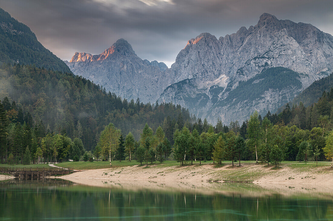 Green lake Jezero Jasna in front of mountain backdrop, shore. Kransjka Gora, Slovenia.