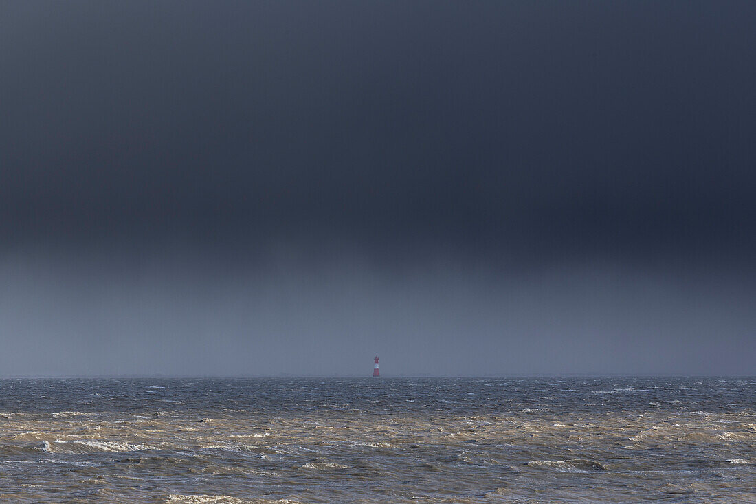 Blick aufs Meer. Nordsee, dunkle Wolken. Leuchtturm in der Ferne. Wilhelmshaven, Jadebusen, Arngast, Niedersachsen, Deutschland