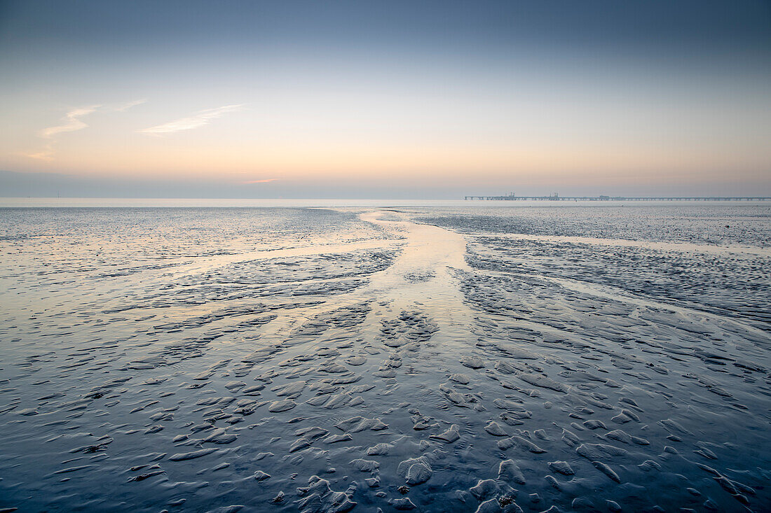 Wide view of the Wadden Sea. Small tideways, sunrise. Hooksiel, Friesland, Lower Saxony, Germany.