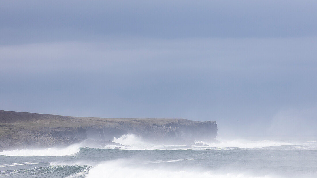 Hohe Wellen, Brandung und Gischt an irischer Steilküste. Ross, Kilballyowen, County Clare, Irland.