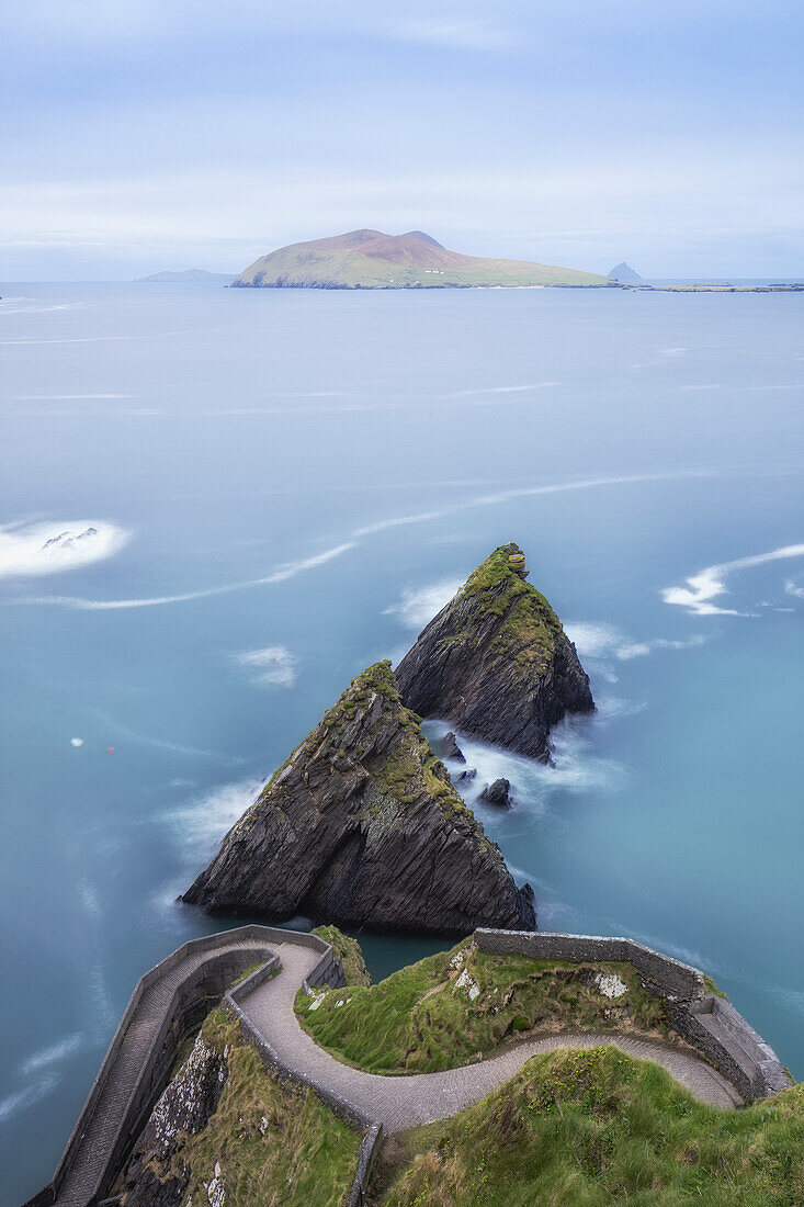 Geschlängelter Weg zum Dunquin Pier und Felsnadeln im Meer. Ballyickeen Commons, County Kerry, Irland.