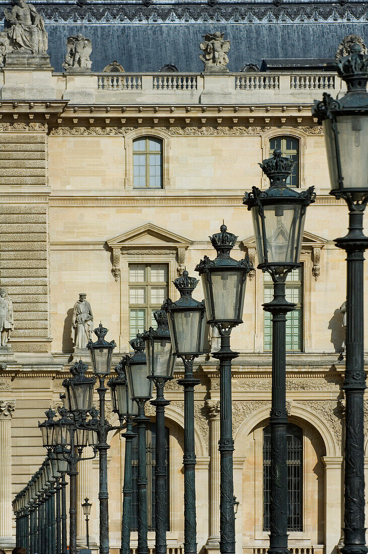 Reihe von Lampen, architektonischen Details und Statuen im Louvre-Museum, Paris, Frankreich