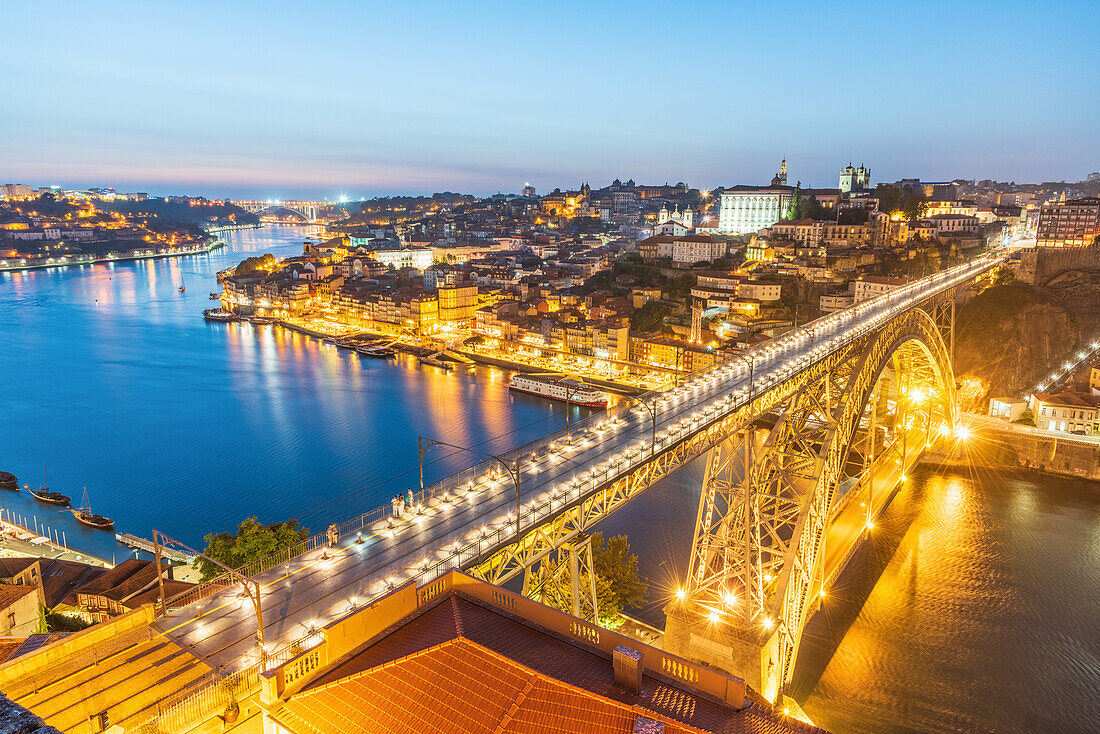 Dom Luís I half-timbered arch bridge over Douro river and historic old town at night in Porto, Portugal