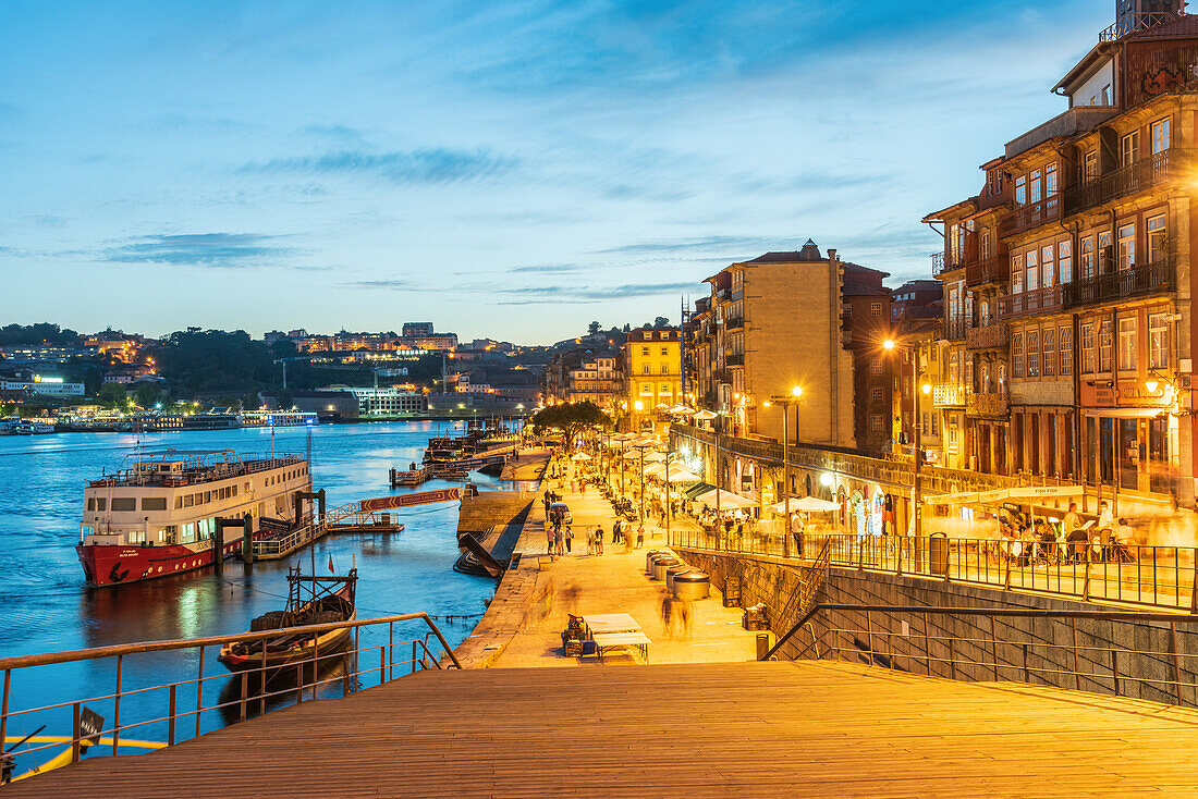 Nachtaufnahme der Uferpromenade Cais de Ribeira und der historischen Altstadt von Porto, Portugal