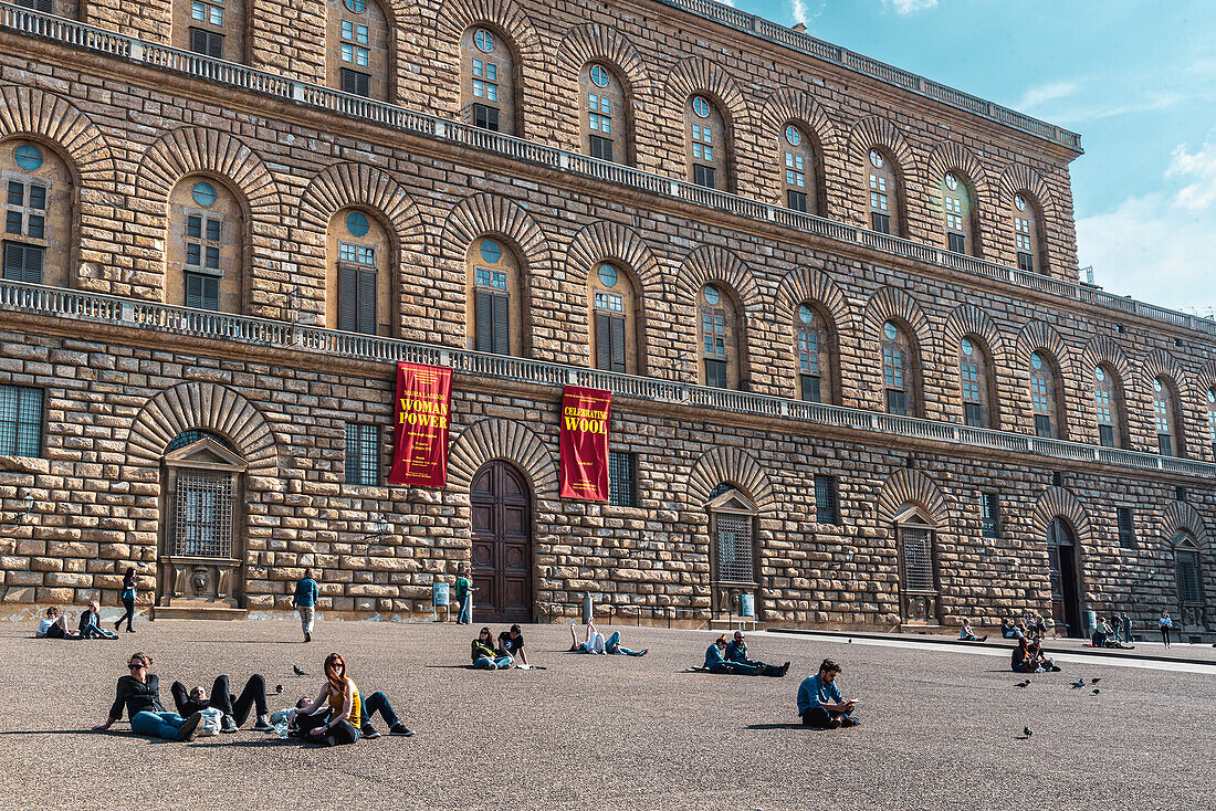 People lying or sitting in front of the Palazzo Pitti Renaissance palace in the Oltrarno district of Florence, Florence, Tuscany, Italy, Europe