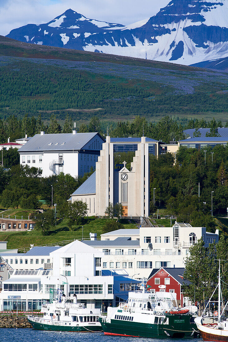 View across the harbor to the imposing Akureyrarkirkja Evangelical Lutheran Church on a hill, with many stained glass windows and a large organ.