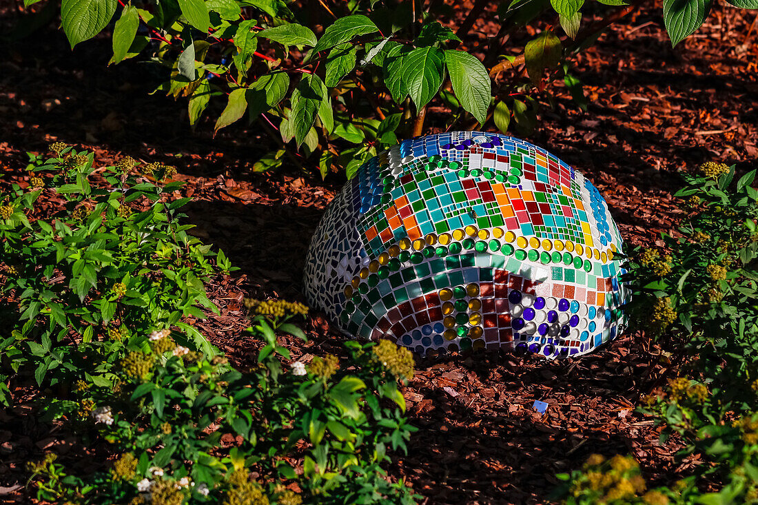 Garden art presented as a mosaic on a sphere that is only half visible