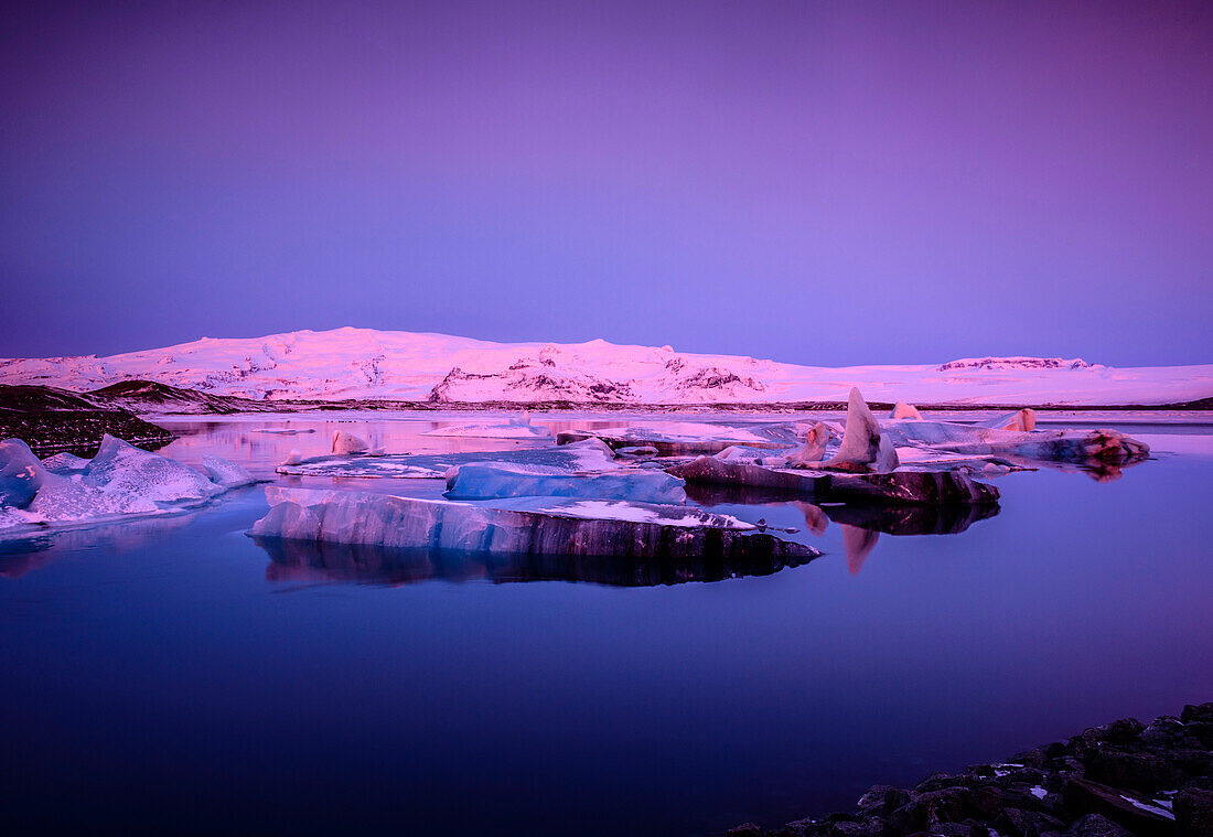 Eisschollen in Island in rosa Licht in der Abenddämmerung