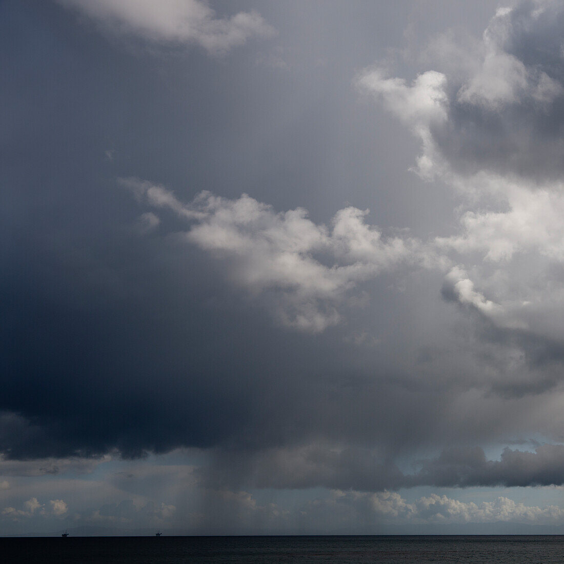 Bewölkter dunkler Himmel über flacher ländlicher Landschaft.