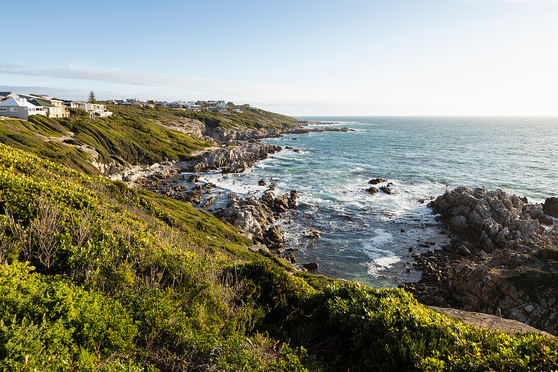 Blick von oben auf eine zerklüftete Felsküste, Klippen und Weg zum Strand und Meer.