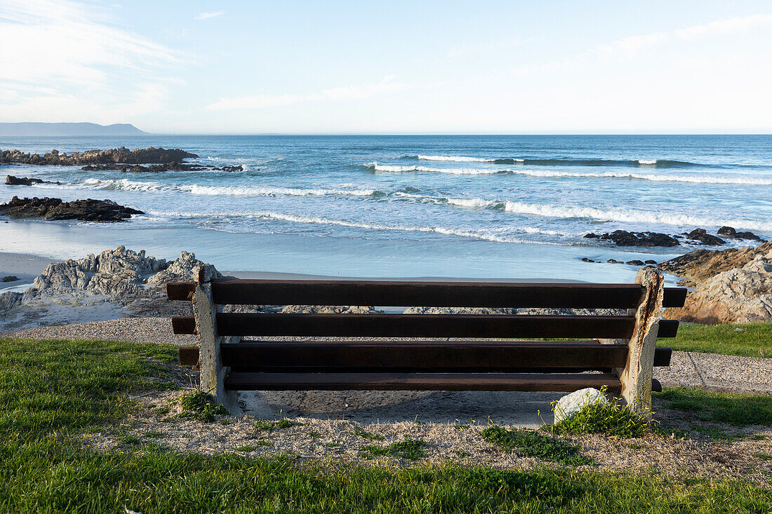 Bench overlooking a beach, jagged rocks and rockpools on the Atlantic coast, South Africa