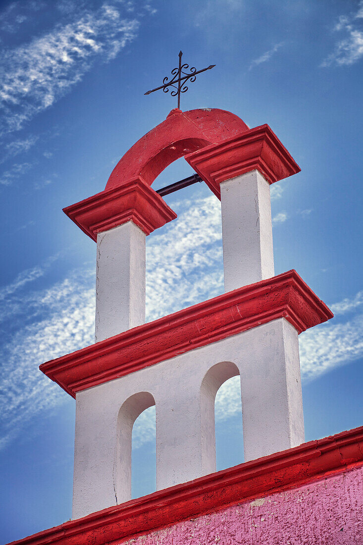 Architectural detail, red and white paint and iron cross on a church rooftop in Cancun, Yucatan Peninsula, Mexico