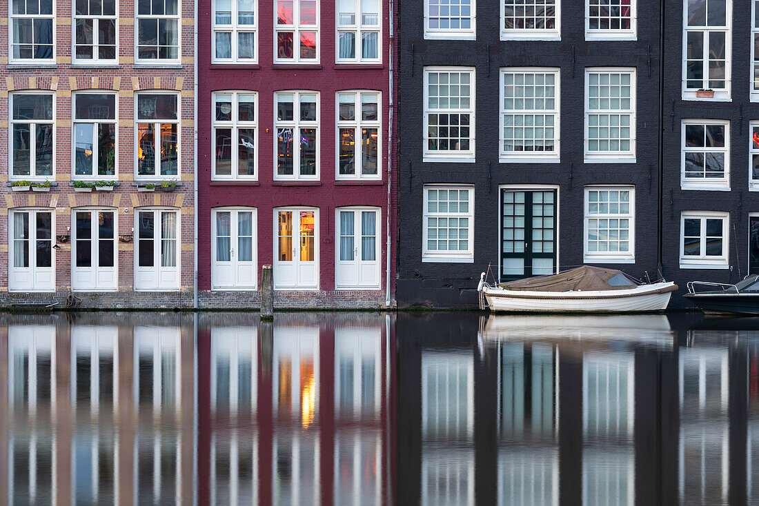 Typical Amsterdam houses with reflections in the Damrak Canal, Amsterdam, North Holland, Netherlands