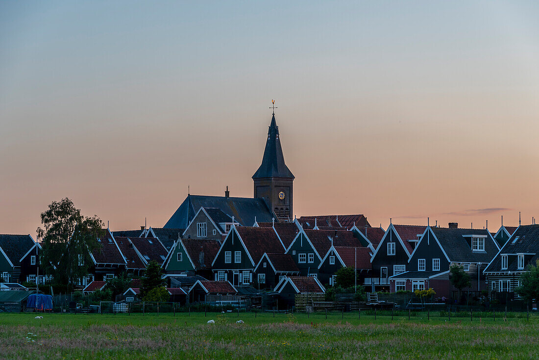 Sunset, traditional dwelling houses, village church, Marken peninsula, Waterland, North Holland, Netherlands