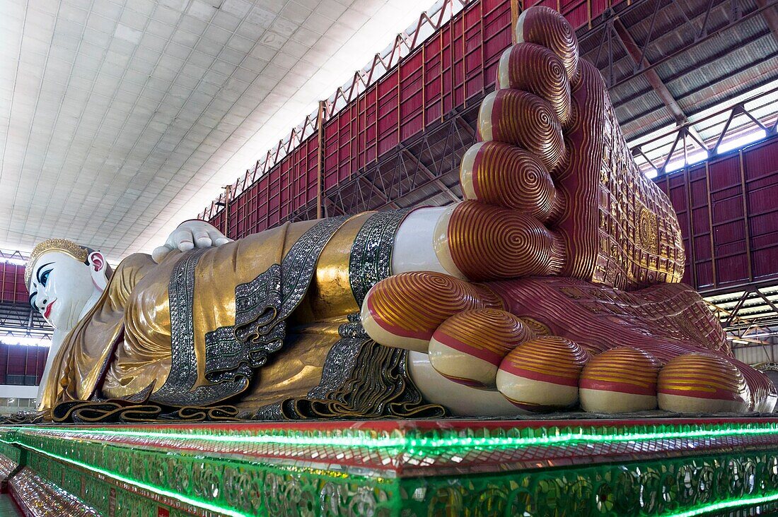 Myanmar (früher Burma). Yangon (Rangun). Die Kyaukhtatgyi-Pagode beherbergt einen großen, 70 Meter langen, liegenden Buddha. Seine Fußpflanzen tragen die 108 heiligen Merkmale, die ihn von gewöhnlichen Sterblichen unterscheiden. Dieser riesige Buddha, einer der größten des Landes, ist mit Gold und Edelsteinen geschmückt.