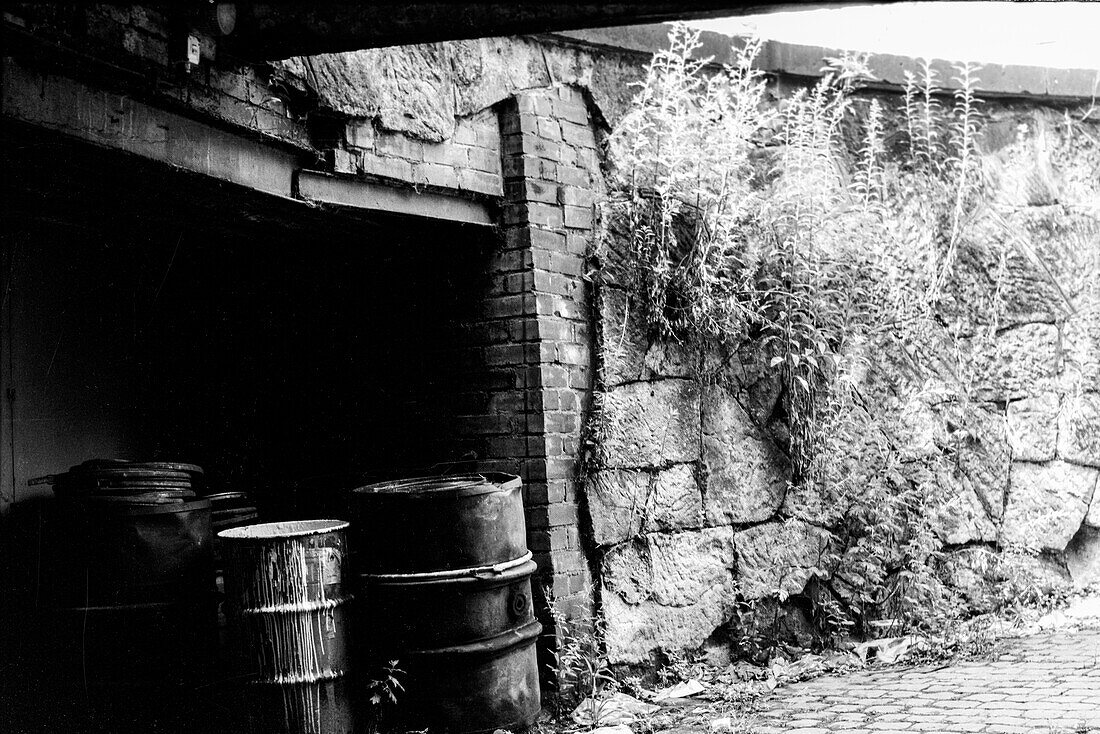 Chemnitz,former Karl Marx Stadt,East Germany. Old and decomissioned oil drums,stached away in a driveway for collection inside the former DDR town,just after Die Wende,1991. Shot on Analog Black & White Film.