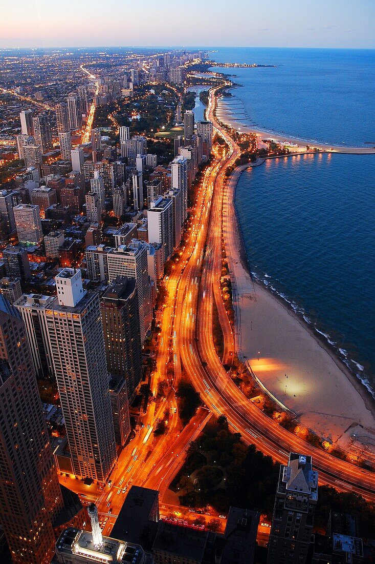 Traffic illuminates Lake Shore Drive in Chicago at dusk.