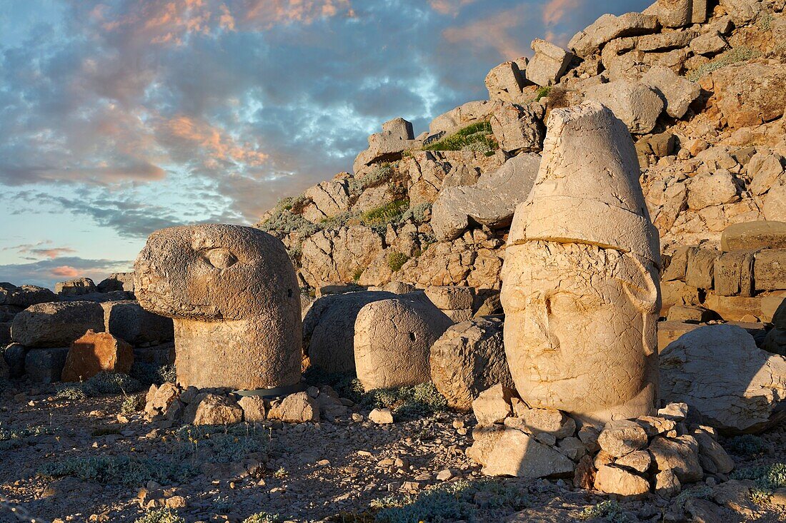 Statue heads at sunrise,from lright,Antiochus & Eagle in front of the stone pyramid 62 BC Royal Tomb of King Antiochus I Theos of Commagene,east Terrace,Mount Nemrut or Nemrud Dagi summit, Turkey.