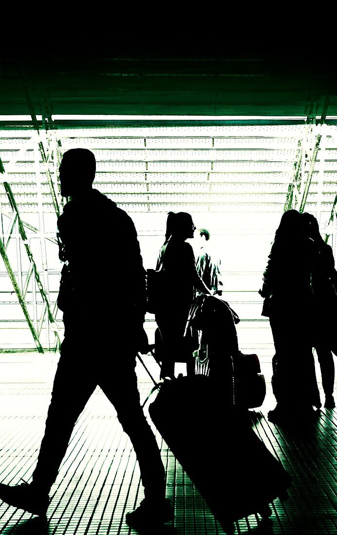 Silhouetten von Menschen auf einem Flughafen.