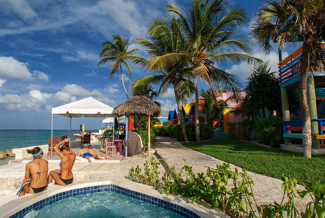 Tourists at swimming pool and spa of Hotel Compass Point Resort at Love beach Nassau,Bahamas,Caribbean. Brightly Colored Cottages At Compass Point Beach Club.