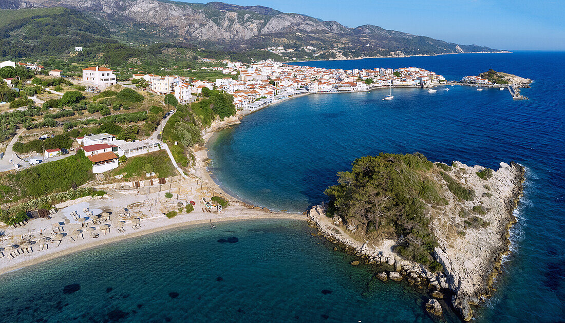 Kokkari, Luftaufnahme von Sunrise Beach, Altstadt und Hafen mit vorgelagerten Felsinseln auf der Insel Samos in Griechenland