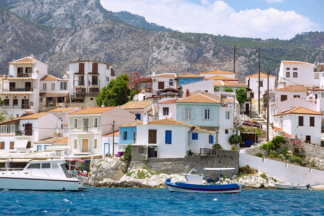 Kokkari, Altstadt mit Gebirgskulisse und Fischerboot im Hafen auf der Insel Samos in Griechenland