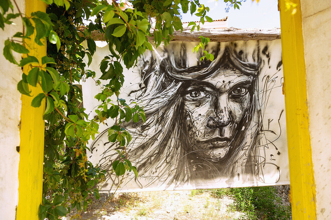 Neo Karlovassi, Kon/nou Kanari street towards the port with street art by Simple G on the island of Samos in Greece